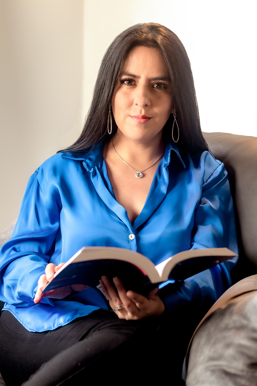 Naty sentada leyendo un libro de coach
